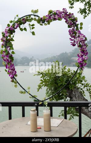 Zwei Gläser Kaffee und ein Herz aus Blumen vor dem blauen Hügelsee von bhimtal nainital zeigen die romantische Lage Stockfoto