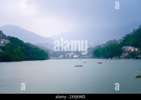 Boote auf dem blauen Wasser inmitten der grünen Hügel von bhimtal nainital zeigen die Schönheit der Bergstationen Stockfoto