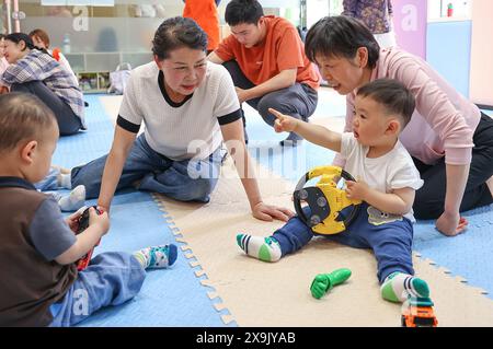 (240601) -- YICHANG, 1. Juni 2024 (Xinhua) -- Kinder tauschen ihr Spielzeug während einer Aktivität in einem CBFS-Zentrum (Community Based Family Support) in der Gemeinde Jinxiu im Bezirk Xiling, Stadt Yichang in der zentralchinesischen Provinz Hubei, 24. April 2024 aus. IM SINNE VON „China Focus: Ländliche gemeindenahe frühkindliche Entwicklungsdienste fördern vielversprechenden Start ins Leben“ (Xinhua/Zhang Yuwei) Stockfoto