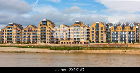 Apartmentkomplex mit Blick auf die Themse. Serie von braunen und blauen Häusern in der Wapping High Street, Wapping, London, Großbritannien. Stockfoto