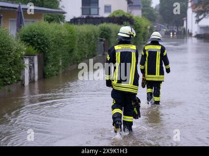 1. Juni 2024, Bayern, Dasing: Feuerwehrleute gehen über eine überflutete Straße in Dasing im schwäbischen Stadtteil Aichach-Friedberg. Foto: Sven Hoppe/dpa Stockfoto