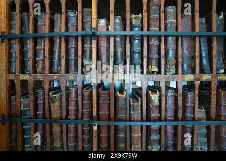 Bücherregal gefüllt mit alten ledergebundenen Hardcover-Büchern. Ein Bücherregal mit mehreren, mehreren großen seltenen antiken Büchern, eine alte Sammlung von Vintage-Büchern. Stockfoto