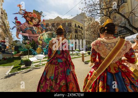 Ein Fallas-Denkmal, farbenfrohe, lustige Skulptur beim berühmten Las Fallas Festival in Valencia, Spanien mit Frauen in traditionellen zeremoniellen spanischen Kleidern. Stockfoto