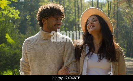 Sorglos verheiratetes multiethnisches Paar hispanische Frau Mädchen afroamerikanischer Mann Junge Walking Point Finger halten Hände. Weibliche Frau, männlicher Ehemann, lächeln Stockfoto