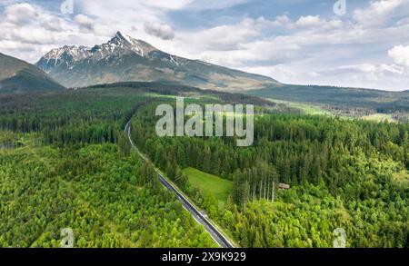Panorama der Hohen Tatra und Straße durch Nadelwald, Strbske, Slowakei Stockfoto