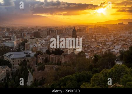 Málaga Panoramablick auf die Skyline bei Sonnenuntergang, während die Alcazaba auf Gibralfaro und die Kathedrale von Malaga leuchten. Malaga, Spanien, Panoramablick auf die Stadt bei Sonnenuntergang Stockfoto