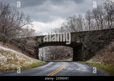 Steinbrücke und Tunnel über den Blue Ridge Parkway an einem verschneiten Wintertag. Stockfoto