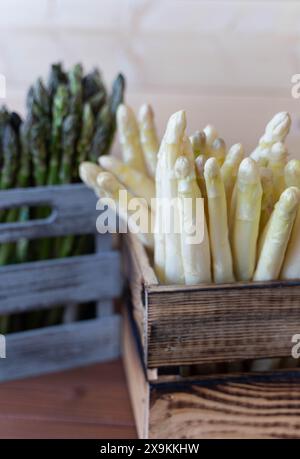 Nahaufnahme einer weißen Spargelkiste vorne mit einer grauen Kiste grüner Spargel hinten Stockfoto
