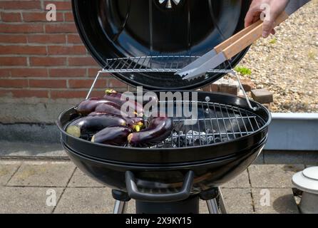 Black Compact Holzkohlegrill Wasserkocher mit gebratenem Gemüse auf der Terrasse, im Garten oder auf dem Dach. Stockfoto