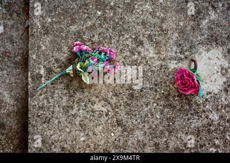 Plastikblumen auf Grab Stockfoto