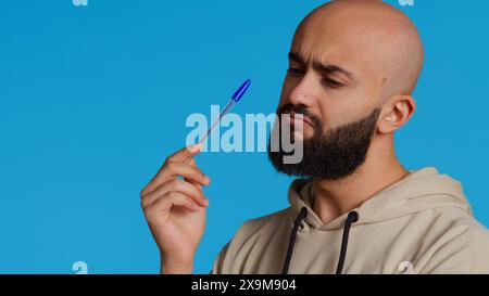 Arabische Person denkt über eine Lösung des Problems nach, handelt nachdenklich und denkt vor der Kamera über Entscheidungen nach. Der Typ aus dem Nahen Osten versucht, neue innovative Ideen zu entwickeln. Kamera 2. Stockfoto