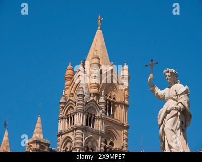 Großes Domgebäude mit gotischem Turm und einer Statue mit einem Kreuz, palermo in sizilien mit einer beeindruckenden Kathedrale, Denkmälern und alten Häusern Stockfoto