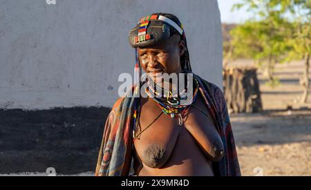 Hakaona-Frau mit traditionellem Kapapo-Haar und bunten Ketten, im Morgenlicht, angolanischer Stamm der Hakaona, in der Nähe von Opuwo, Kunene Stockfoto