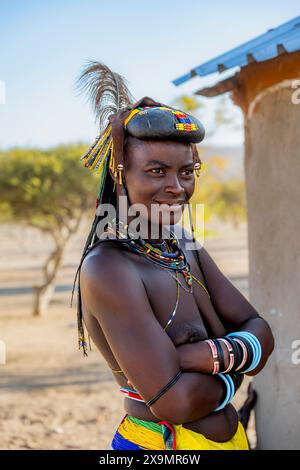 Hakaona-Frau mit traditionellem Kapapo-Haar und Haarschmuck mit Straußenfedern und bunten Halsketten, Porträt, im Morgenlicht Stockfoto