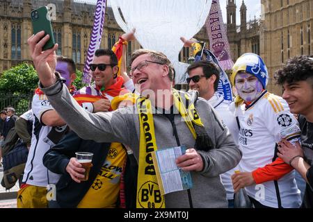 London, UK, 1. Juni 2024. Ein Fan von Borussia Dortmund posiert mit Fans von Real Madrid für ein Selfie auf der Westminster Bridge vor dem Champions League-Finale im Wembley Stadium. Quelle: Eleventh Photography/Alamy Live News Stockfoto