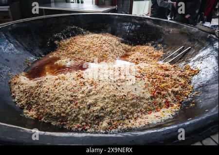 Das orientalische Gericht der usbekischen Küche ist Pilaw in einem riesigen Kessel in der Küche eines asiatischen Restaurants im Taschkent Pilaf Center in Usbekistan Stockfoto