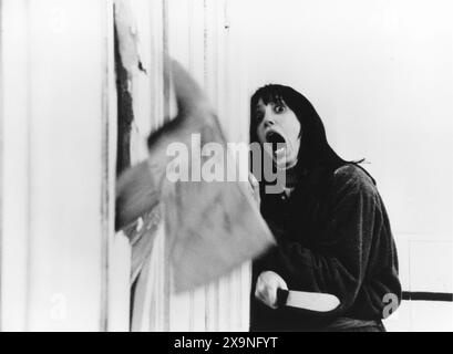 SHELLEY DUVALL in der berühmten Axt-Szene aus DEM GLÄNZENDEN 1980 Regisseur STANLEY KUBRICK Roman STEPHEN KING Warner Brothers Stockfoto