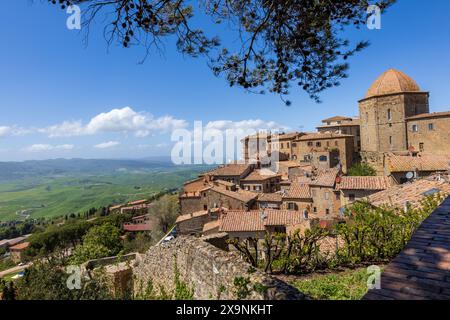 Ein klassischer Blick über die Terrakotta-Dächer, Türme und Kuppel der historischen mittelalterlichen Stadt Volterra in der Toskana, Italien an einem sonnigen Tag mit blauem Himmel. Stockfoto