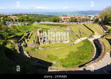 Die wunderschönen Ruinen des römischen Theaters in der historischen mittelalterlichen Stadt Volterra in der Toskana, Italien an einem sonnigen Tag mit blauem Himmel und atemberaubender Aussicht. Stockfoto
