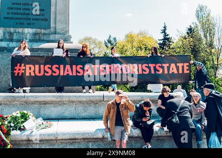 Warschau, Polen. Dezember 2022. Aktivisten stehen auf einem Denkmal zu Ehren sowjetischer Soldaten, während sie ein Banner halten, das besagt, dass Russland am Siegestag ein Terrorstaat ist. Ukrainische Aktivisten protestieren vor dem Friedhof sowjetischer Soldaten. Demonstranten legten Modelle zerstörter ukrainischer Städte und ukrainische Fahnen, die tote Ukrainer symbolisieren, vor dem Eingang zum Friedhof. Der Protest fand am Tag des Sieges am 9. Mai 2023 in Warschau statt. (Credit Image: © Marek Antoni Iwanczuk/SOPA Images via ZUMA Press Wire) NUR REDAKTIONELLE VERWENDUNG! Nicht für kommerzielle ZWECKE! Stockfoto