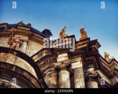 Religiöses Erbe: Kunstvoll verzierte Kirche mit Skulpturen und goldenen Elementen, die an einem hellen Tag festgehalten werden. Die Dominikanerkirche und das Kloster in Lemberg. Stockfoto