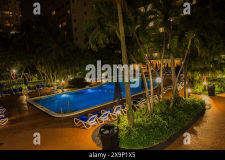 Das Radisson Hotel umgibt eine ruhige nächtliche Atmosphäre, begleitet von schwankenden Palmen neben einem schimmernden Außenpool. Miami Beach. USA. Stockfoto