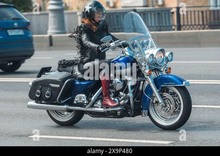 Moskau, Russland - 26. Mai 2024: Eine Motorradfrau mittleren Alters erkundet das Stadtbild auf ihrem klassischen Motorrad. Stockfoto