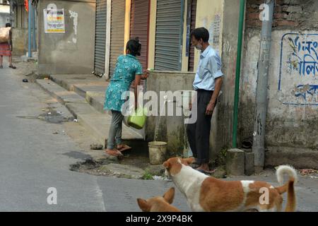 Siliguri, Westbengalen, Indien. Juni 2024. Die Bewohner füllen Wasserflaschen und -Gläser aus einem Wasserhahn der Siliguri Municipal Corporation (SMC) in Siliguri, nachdem die Trinkwasserversorgung von heute an wieder aufgenommen wurde. Die gesamten Gebiete, einschließlich 47 Gemeinden unter Siliguri Municipal Corporation, sind mit den Trinkwasserproblemen konfrontiert, die im letzten Jahr durch die Sturzfluten im Fluss Teesta verursacht wurden, die die Trinkwasseraufbereitungsanlagen bewirkten, in denen das Trinkwasser an die verschiedenen Stationen in Siliguri geliefert wurde. (Kreditbild: © Diptendu Dutta/ZUMA Press Wire) NUR REDAKTIONELLE VERWENDUNG! Nicht für kommerzielle ZWECKE! Stockfoto