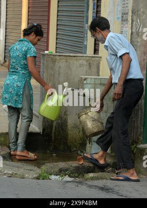 Siliguri, Westbengalen, Indien. Juni 2024. Die Bewohner füllen Wasserflaschen und -Gläser aus einem Wasserhahn der Siliguri Municipal Corporation (SMC) in Siliguri, nachdem die Trinkwasserversorgung von heute an wieder aufgenommen wurde. Die gesamten Gebiete, einschließlich 47 Gemeinden unter Siliguri Municipal Corporation, sind mit den Trinkwasserproblemen konfrontiert, die im letzten Jahr durch die Sturzfluten im Fluss Teesta verursacht wurden, die die Trinkwasseraufbereitungsanlagen bewirkten, in denen das Trinkwasser an die verschiedenen Stationen in Siliguri geliefert wurde. (Kreditbild: © Diptendu Dutta/ZUMA Press Wire) NUR REDAKTIONELLE VERWENDUNG! Nicht für kommerzielle ZWECKE! Stockfoto