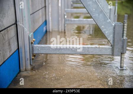 Weltenburg, Deutschland. Juni 2024. Wasser sickert durch eine mobile Hochwassersperre an der Zufahrtsstraße zum Kloster Weltenburg. Für den Landkreis Kelheim in Niederbayern wurde wegen der Überschwemmungen und der steigenden Wasserstände der Ausnahmezustand ausgerufen. Dies wurde von der Bezirksverwaltung am Sonntag bekannt gegeben. Quelle: Pia Bayer/dpa/Alamy Live News Stockfoto