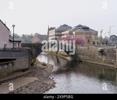 Bridgend's Zwillingsbogen mittelalterliche Brücke über den Fluss Ogwr. Sie wurde um 1425 erbaut. Dahinter befinden sich die Crown Buildings in der Angel Street. Stockfoto