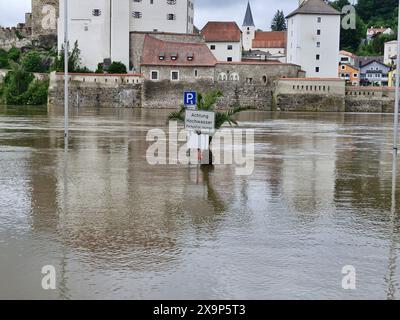 Passau, Deutschland. Juni 2024. Ein Schild steht im Hochwasser. Auch die niederbayerische Dreiflusstadt Passau hat durch den starken Regen mit erheblichen Überschwemmungen zu kämpfen. Der Donauspiegel stieg nach Angaben des Hochwasserinformationsdienstes am Sonntag auf über 7,70 Meter. Zahlreiche Straßen und Plätze in der Stadt sind unter Wasser. Quelle: Markus Zechbauer/Zema Medien/dpa/Alamy Live News Stockfoto