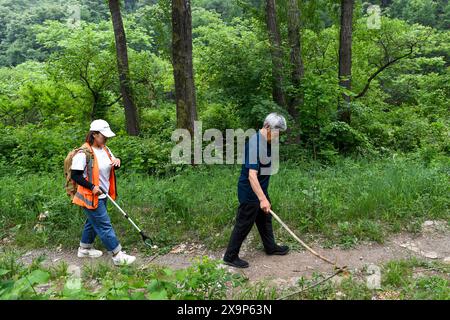 (240602) -- PEKING, 2. Juni 2024 (Xinhua) -- Mei Jingtian (R) und Liu Hongyan sind auf dem Weg, die Chinesische Mauer im Dorf Shixia im Bezirk Yanqing von Peking, Hauptstadt Chinas, am 23. Mai 2024 zu patrouillieren. Seit Anfang der 1980er Jahre begann Mei spontan mit dem Schutz der Chinesischen Mauer und hat bei vielen Dorfbewohnern das Bewusstsein für den Schutz der Chinesischen Mauer geschärft. Das Dorf Shixia im Bezirk Yanqing in Peking wurde in der Ming-Dynastie (1368–1644) erbaut und war einst ein wichtiger Pass im Norden des Juyongguan-Abschnitts der Chinesischen Mauer. Das Dorf, das von Bergen umgeben ist, hat ein bis entwickelt Stockfoto