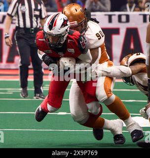 Jacksonville, Florida, USA. Juni 2024. Indoor Football League, Jacksonville Sharks gegen Arizona Rattlers. Sharks QB N’Kosi Perry (7) wird von Rattlers DL Seyvon Lowry (90) eingepackt. Foto: Tim Davis/Alamy Live News Stockfoto