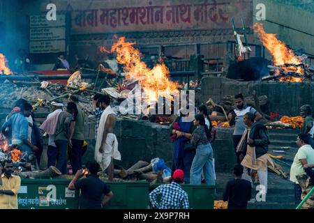 Einheimische und Besucher werden Zeugen heiliger Trauerhaufen als Teil der hinduistischen Rituale am Ufer des ganges Stockfoto