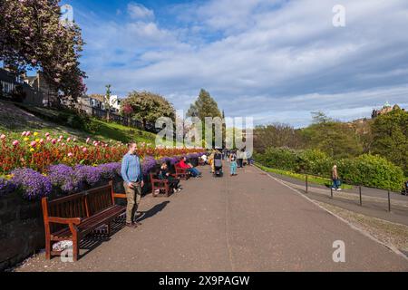 Edinburgh, Schottland, Vereinigtes Königreich - 9. Mai 2023: Menschen in Princes Street Gardens im Frühjahr, Park Gasse gesäumt von Blumen und Bänken im Stadtzentrum. Stockfoto