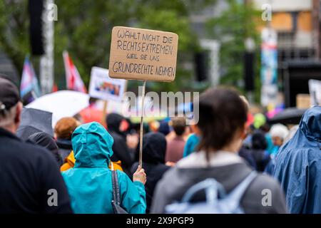 Freiburg, Deutschland. Juni 2024. Ein Teilnehmer einer Demonstration gegen Rechtsextremismus steht auf dem Platz der Alten Synagoge in Freiburg und trägt ein Schild mit der Aufschrift "stimmt nicht für die Rechtsextremisten, weil sie uns unsere Grundrechte nehmen". Rund acht bis zehntausend Menschen nahmen an der Demonstration Teil, die auch ein Signal gegen den Rechtsextremismus im Hinblick auf die Europa- und Kommunalwahlen setzen sollte. Quelle: Philipp von Ditfurth/dpa/Alamy Live News Stockfoto