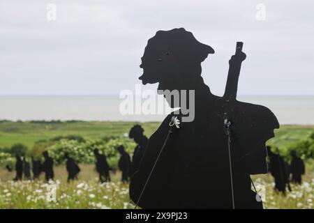 Normandie, Frankreich. Juni 2024. Die Statuen der Statuen der Gedenkstätte Standing with Giants befinden sich inmitten tausender Wildblumen in Vorbereitung auf die Zeremonie zum 80. Jahrestag des D Day, die am Donnerstag, den 6. Juni stattfinden soll. Mit dem Titel „for Your Tomorrow“ beträgt die Gesamtzahl der Statuen 1475 mit einem geneigten Kopf, der einen verlorenen Soldaten am DDay darstellt. Am Donnerstag werden viele Staatsoberhäupter, Veteranen und Beamte empfangen, die den 80. Jahrestag der Landungen des D-Day und der Schlacht in der Normandie gedenken werden. Credit: Casper Farrell/Alamy News Credit: Casper Farrell Photography/Alamy Stockfoto