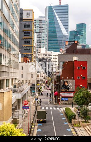 Typische städtische Straße, flankiert von hohen Gebäuden, in den Roppongi Hills in Tokio, mit dem neuen Sumitomo Fudosan Roppongi Grand Tower im Hintergrund Stockfoto