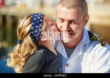 Kuss, Kind und Vater mit Uniform für Liebesbeziehung, Navy SEAL und Militär Helden mit Unterstützung. Dad, junges Mädchen und umarme dich mit Marinesoldaten Stockfoto