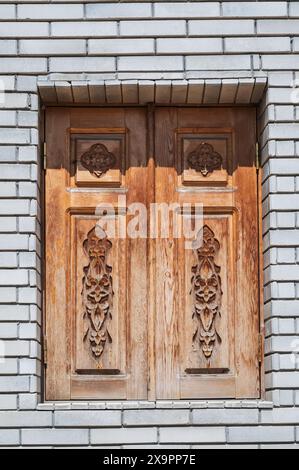 Hölzerne Fensterläden am Fenster mit orientalischem usbekischen Schnitzmuster verzierte Ornamente in Usbekistan in Taschkent Stockfoto