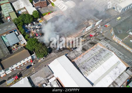 Birmingham, Großbritannien. Juni 2024. Die West Midlands Fire Service verfügt über 10 Pumpen mit rund 50 Feuerwehrleuten, eine hochvolumige Besatzung und eine hydraulische Plattform, die bei einem Brand in einer Industrieeinheit in der Lower Tower Street in Newtown, Birmingham, anwesend ist. Der Rauch konnte man meilenweit in der Stadt sehen. Ein Anruf von 999 kam um 15:20 Uhr zu einem großen Feuer im Industriegebäude. Die Feuerwehrleute versuchen nun, eine Brandausbreitung auf benachbarte Grundstücke zu verhindern. Dem Vernehmen nach enthält der Hof eine unbekannte Anzahl von Zylindern. Es wurde nicht berichtet, dass jemand verletzt wurde. Quelle: Stop Press Media/Alamy L Stockfoto