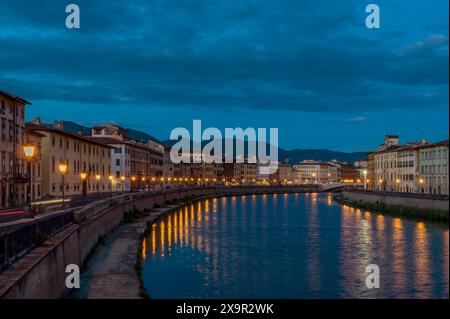 An den Fenstern von Gebäuden entlang des Flusses Arno in Pisa, Italien, sind weiße Lichthalter in verschiedenen Formen angebracht Stockfoto