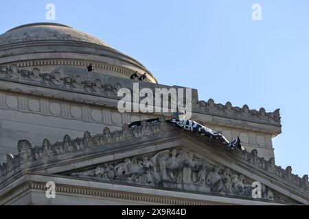 Brooklyn, NY - Mai 31 2024: Polizeibeamte der NYPD blicken während des Protestes an der Fassade des Brooklyn Museums an Ostern vom Dach mit Pro Palestine-Schild Stockfoto