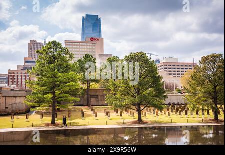 Oklahoma City, Oklahoma USA - 17. März 2017: Ein Paar schlendert zwischen leeren Stühlen und dem Reflecting Pool im Oklahoma City National Memorial in Stockfoto