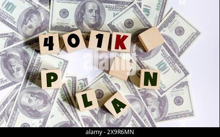 Geschäfts- und Finanzkonzept. Auf dem Tisch stehen Dollar und eine farbige Haftnotiz, auf der steht 401K-PLAN. Stockfoto