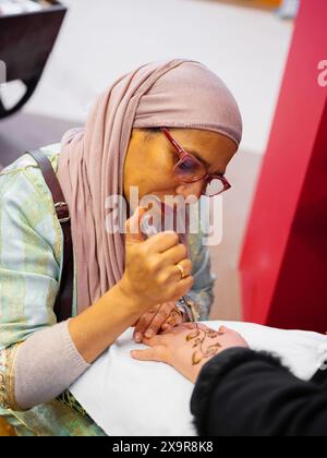 Berlin, Deutschland 20.01. 2023 Mehndi-Meister, der Henna-Tattoo auf weiblicher Hand zeichnet, Mehendi-Kunst Stockfoto