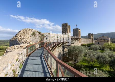 Der Fußweg und die Türme an den Stadtmauern der historischen mittelalterlichen Stadt Monteriggioni in der Toskana, Italien an einem sonnigen Tag mit blauem Himmel. Stockfoto