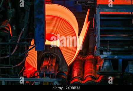 30. Mai 2024, Brandenburg, Eisenhüttenstadt: Ein rotglühender Stahlspule im Warmwalzwerk der ArcelorMittal Eisenhüttenstadt GmbH. Foto: Patrick Pleul/dpa Stockfoto