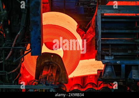 30. Mai 2024, Brandenburg, Eisenhüttenstadt: Ein rotglühender Stahlspule im Warmwalzwerk der ArcelorMittal Eisenhüttenstadt GmbH. Foto: Patrick Pleul/dpa Stockfoto